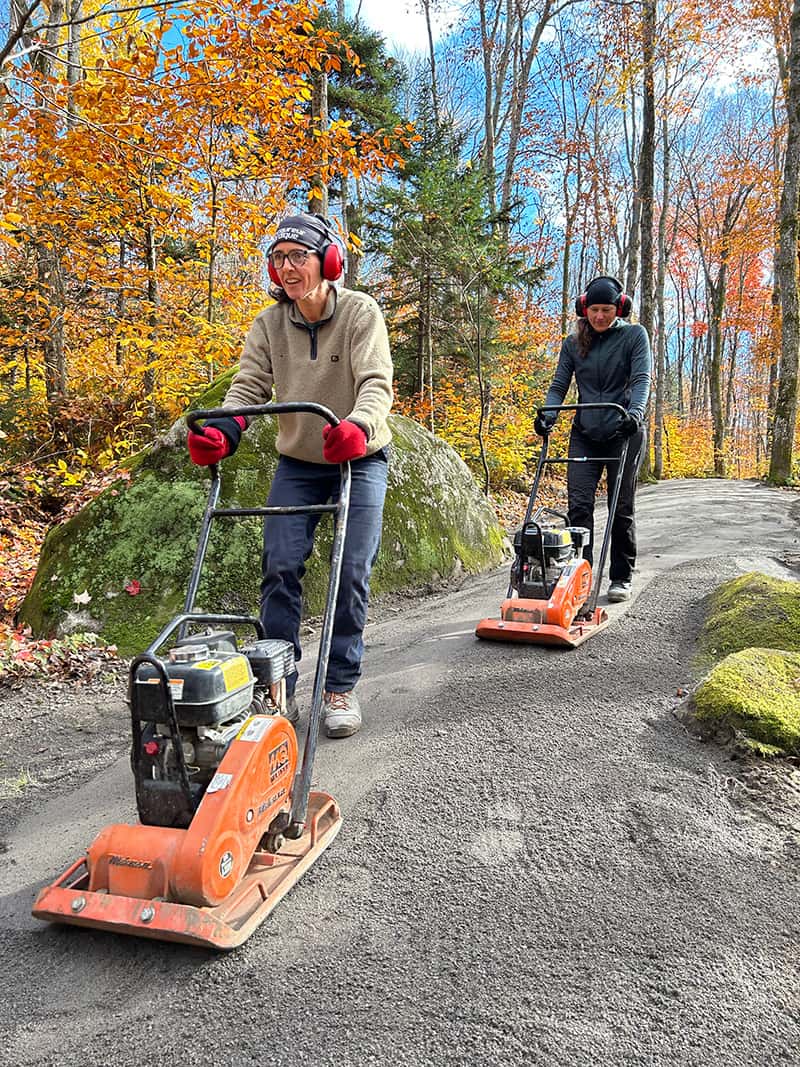 Deux femmes opérant de la machinerie pour égaliser un sentier du Mont-Bélair.